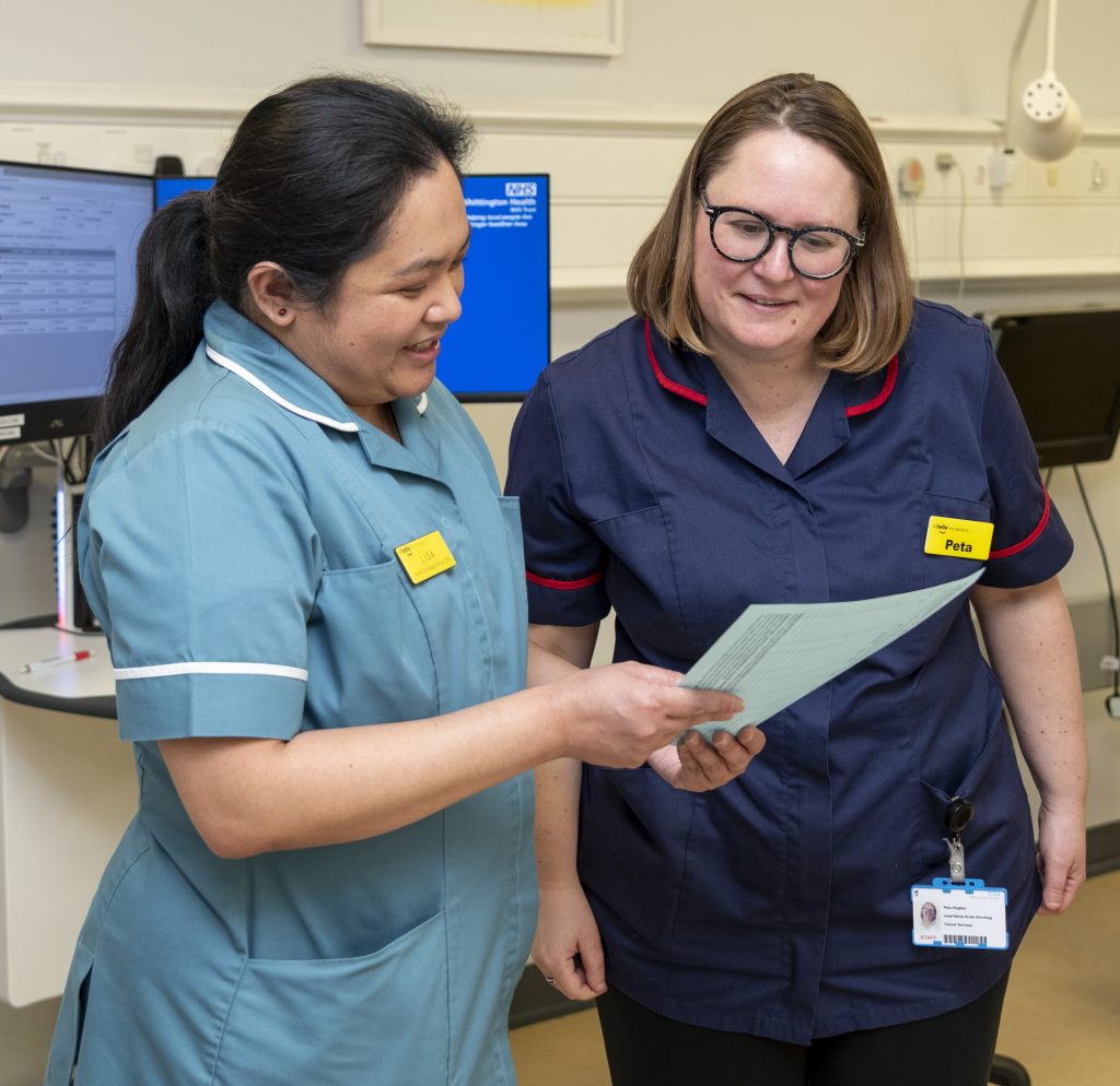 Two cancer clinical nurse specialists in discussion over some notes (Whittington Hospital)