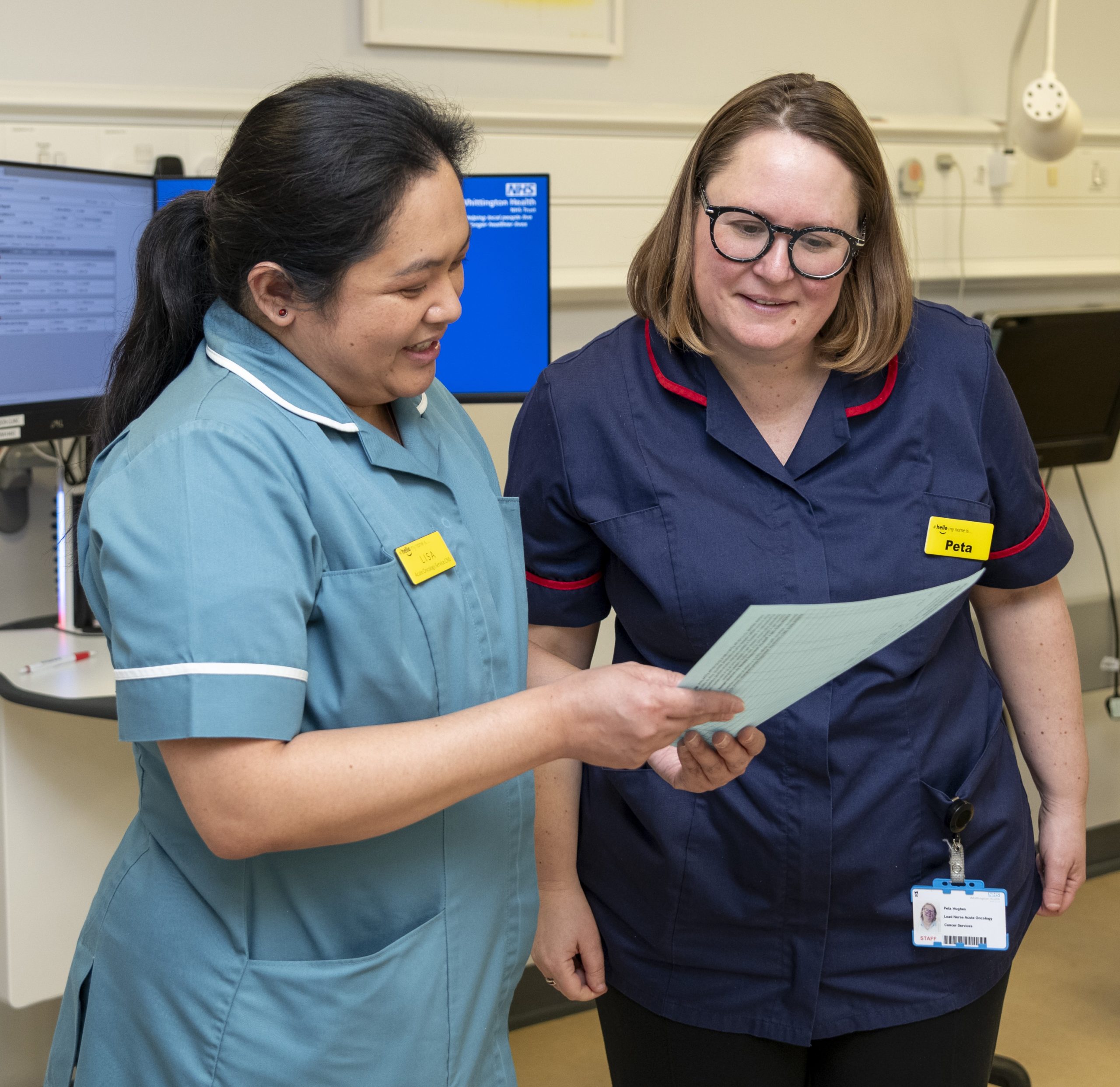 Two cancer clinical nurse specialists in discussion over some notes (Whittington Hospital)