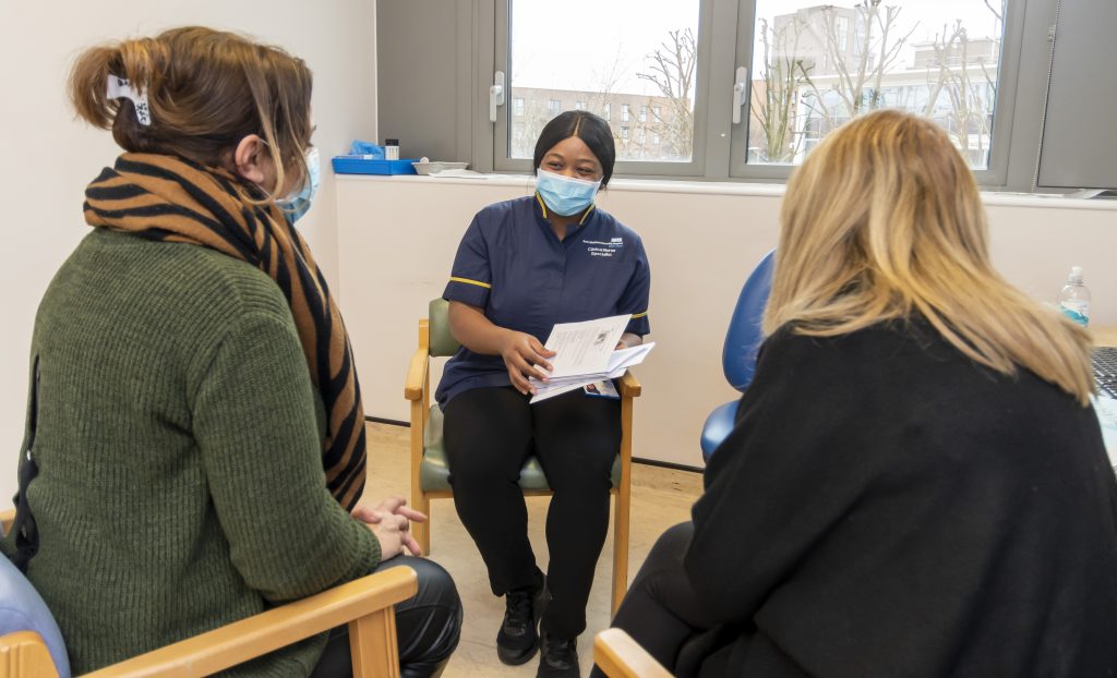 A cancer clinical nurse specialist shares information with a patient's family members.