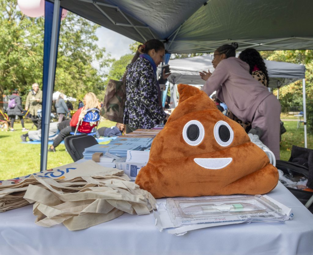 Poo emoji cushion on a table at a stall at Streets Fest health promotion event in Finsbury Park