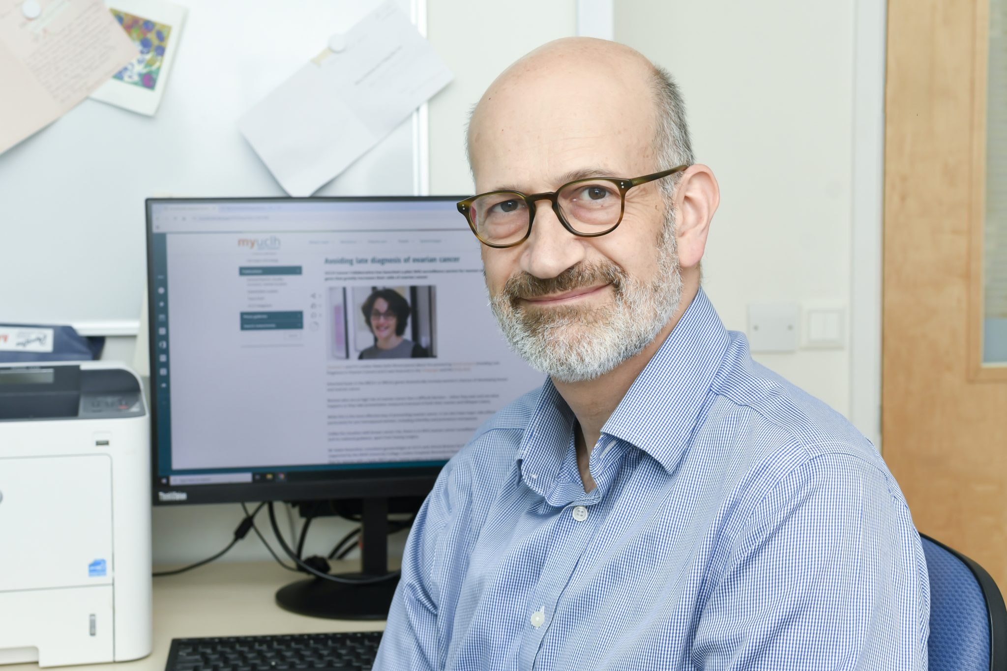 Professor Adam Rosenthal, consultant gynaecologist, UCLH, Sitting in front of a computer screen showing the story of a woman at high of ovarian cancer.